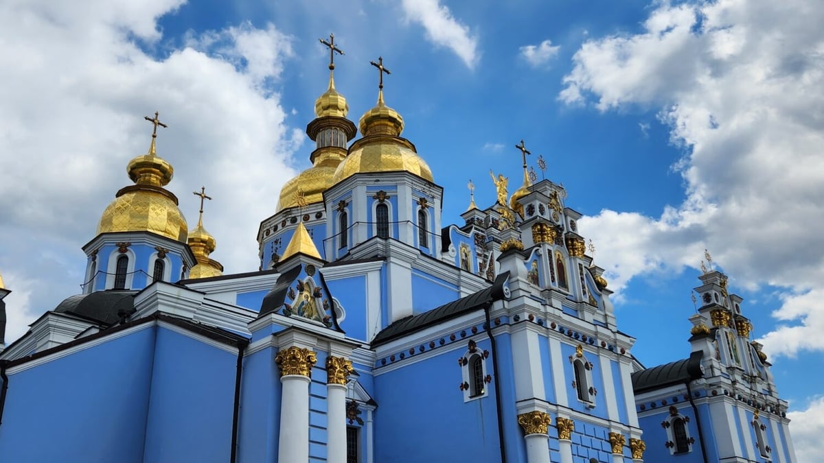 Golden domes of a Ukrainian Orthodox church against a blue sky.
