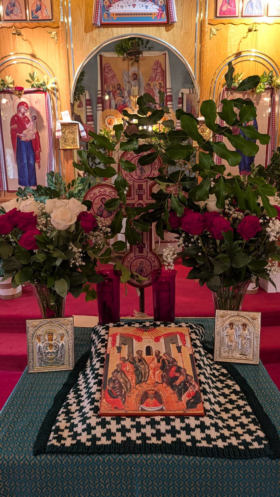 Tetrapod with the Pentecost icon flanked by twin festal rose arrangements