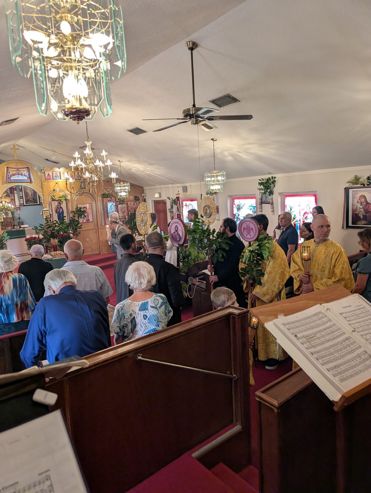 Pentecost procession viewed from the choir loft, with parishioners in the pews