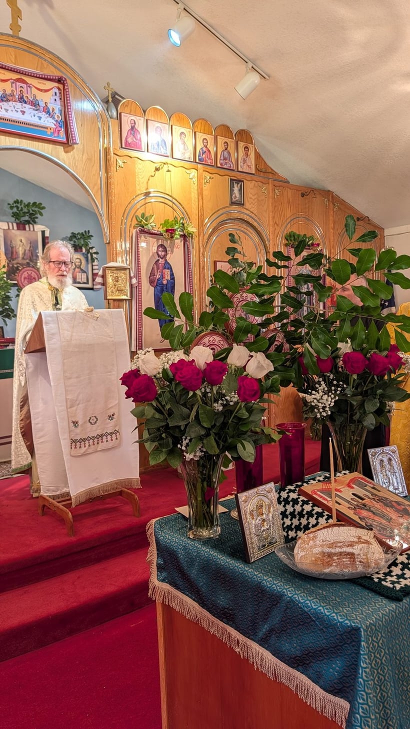 Fr. Stephen Siniari serving before the iconostasis at St. Michael, with the offering bread and flowers.