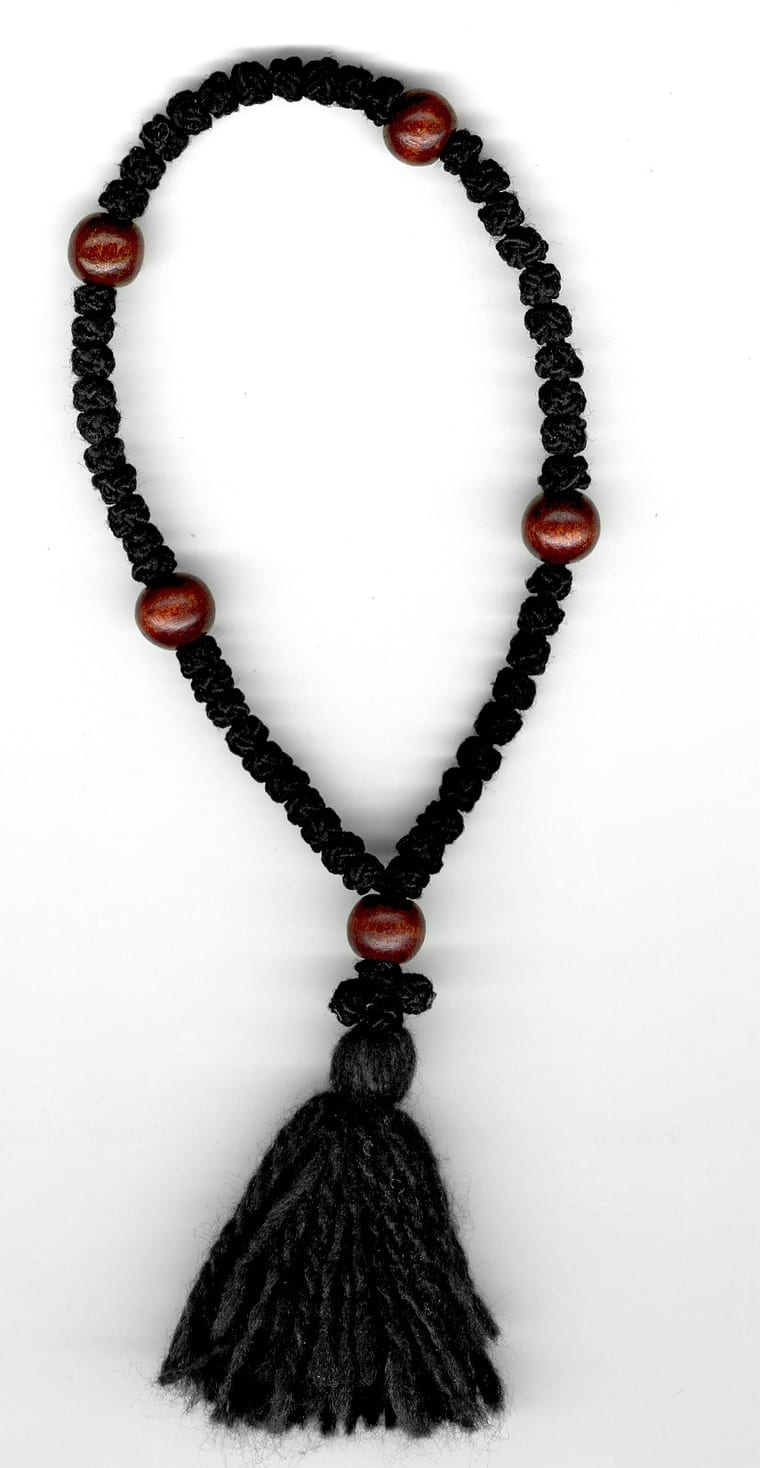 A black wool Orthodox prayer rope with wooden bead dividers and a tassel.